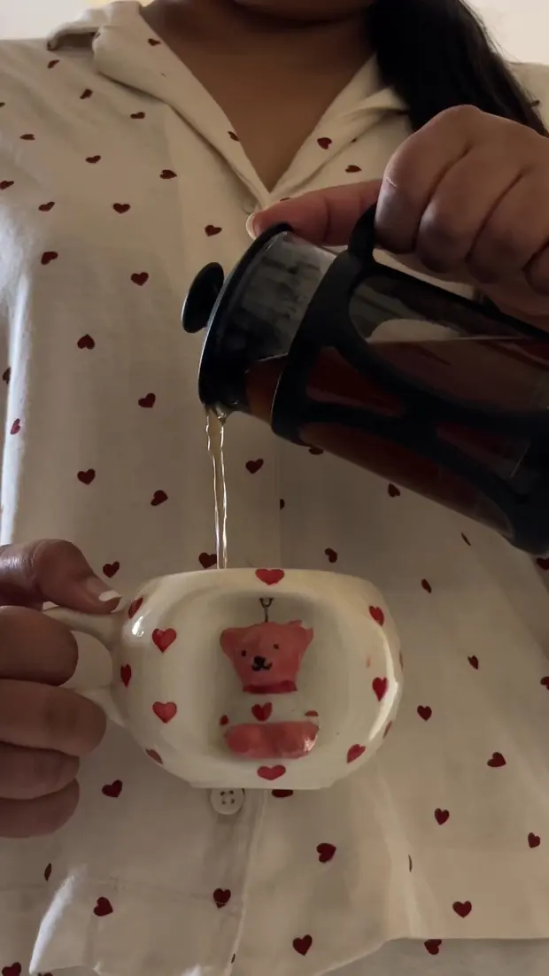 Pouring coffee into a hand-painted ceramic mug