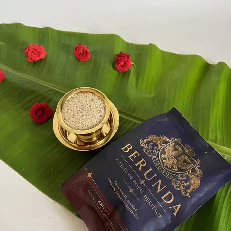 Filter coffee in a brass tumbler on a banana leaf